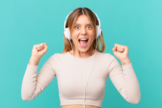 Young woman with headphones shouting aggressively with an angry expression