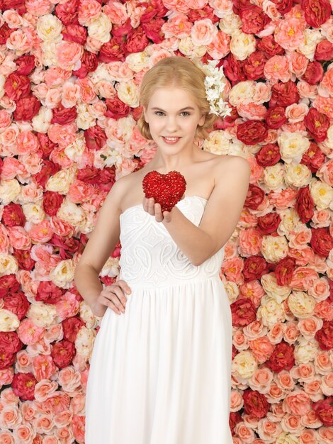 young woman with heart and background full of roses