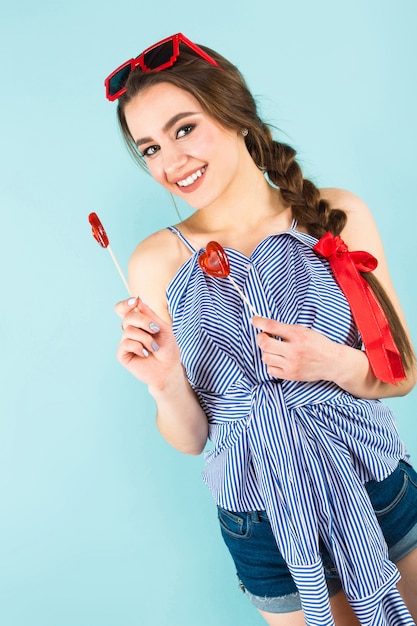 Young woman with heart shaped lollipops