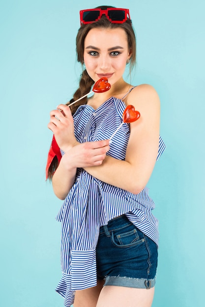 Photo young woman with heart shaped lollipops