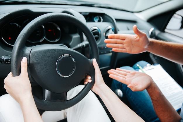 車の中で彼女の自動インストラクターと若い女性