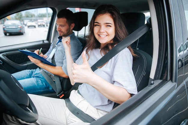 車の中で彼女の自動インストラクターと若い女性