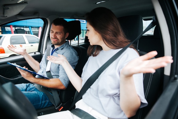 写真 車の中で彼女の自動インストラクターと若い女性