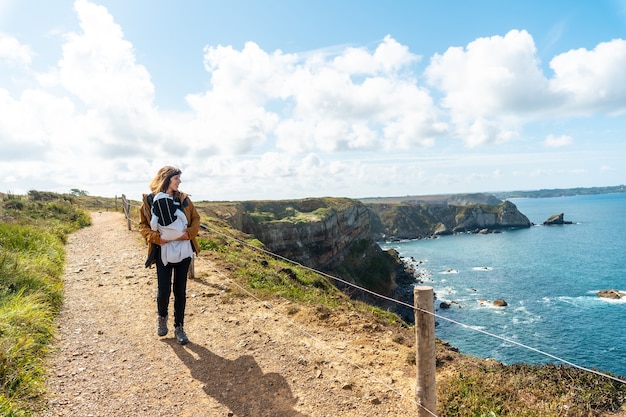 Photo a young woman with her baby on the coast next to the fort des capucins a rocky, cliff-side islet in the town of roscanvel, on the crozon peninsula in france.