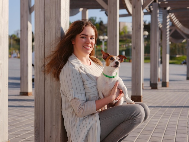 Young woman with her cute Jack Russell Terrier outdoor