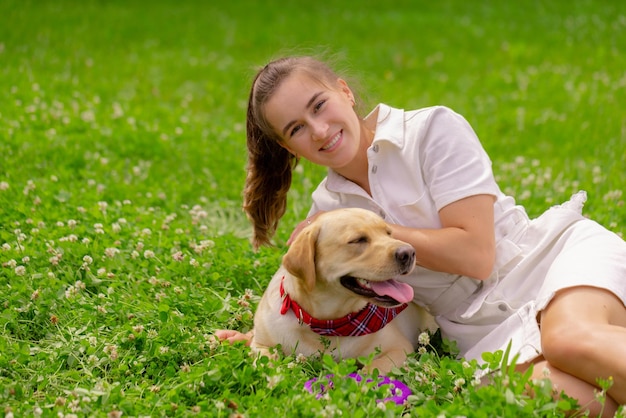 Young woman with her cute yellow labrador outside lovely pet\
animal love concept