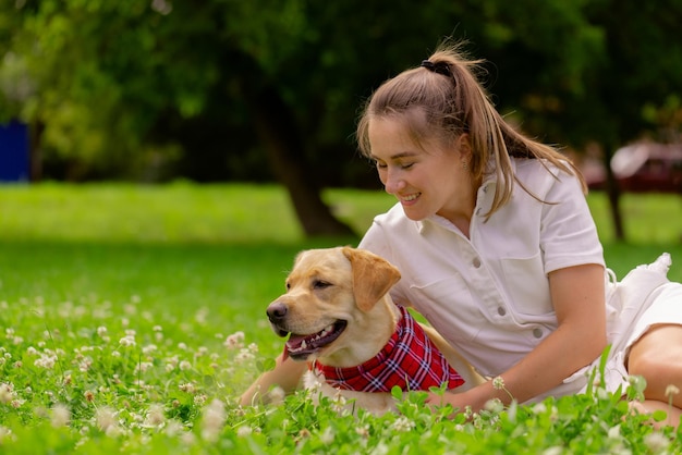 Young woman with her cute yellow labrador outside lovely pet\
animal love concept
