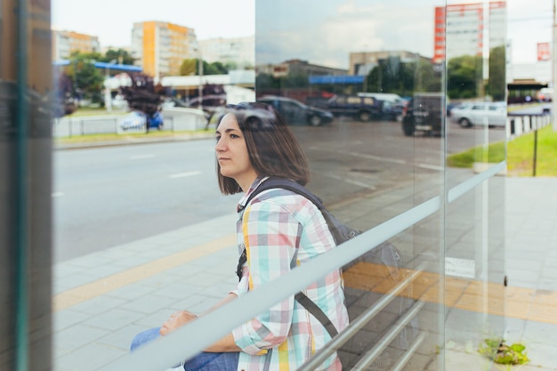 A young woman with her daughter is waiting for a public bus at the bus station