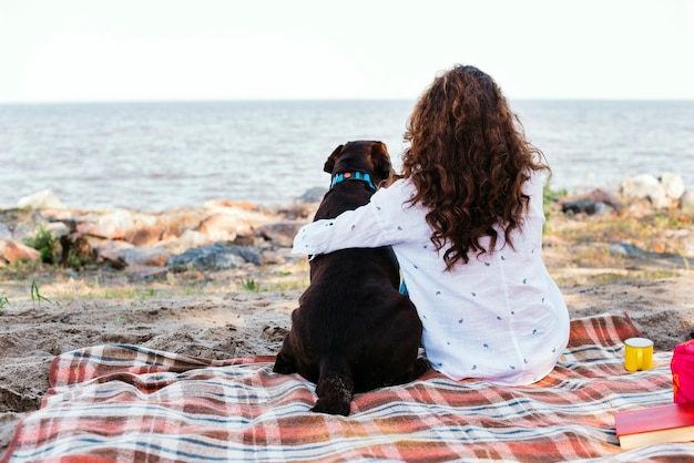 写真 ビーチで彼女の犬を持つ若い女