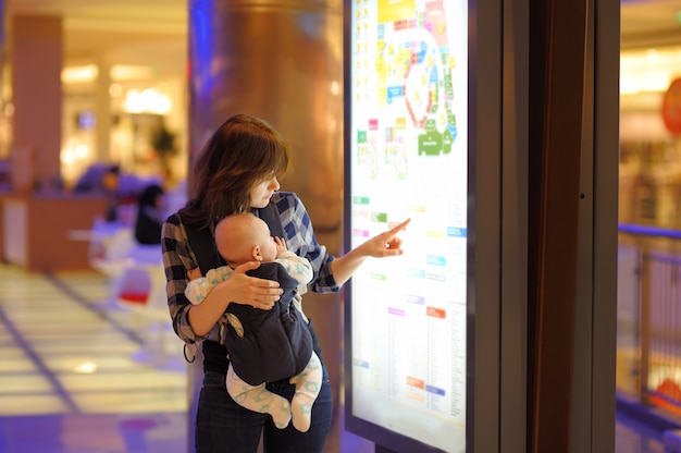 Young woman with her little baby in a shopping mall