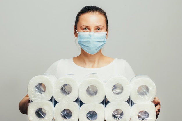 Photo young woman with holds a lot of toilet paper packages.