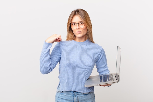 Young woman with a laptop looking arrogant, successful, positive and proud