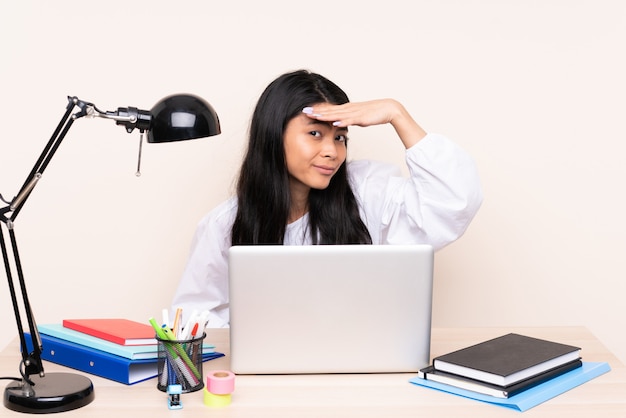 Young woman with a laptop sitting at a table