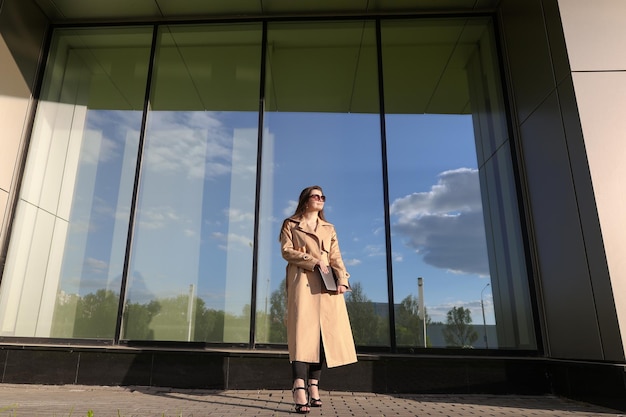 A young woman with a laptop walking through city street