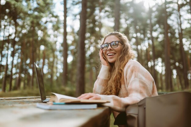 Молодая женщина с ноутбуком работает или учится онлайн на открытом воздухе Видеоконференция по ведению бизнес-блога