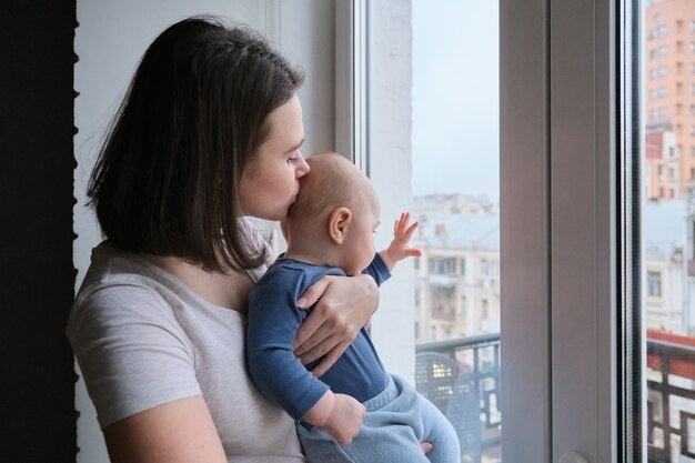 彼女の腕の中で小さな赤ちゃんの息子を持つ若い女性