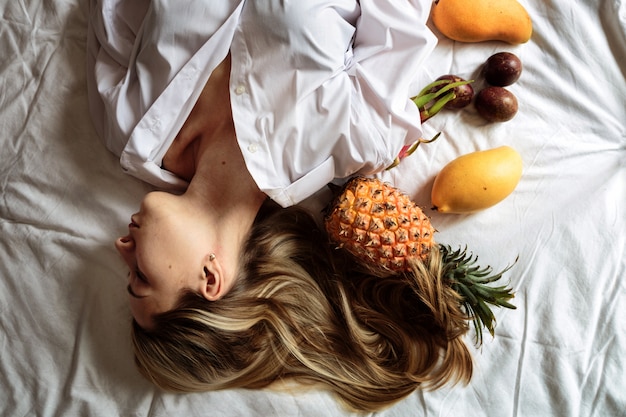 Giovane donna con lunghi capelli biondi sdraiato sul letto