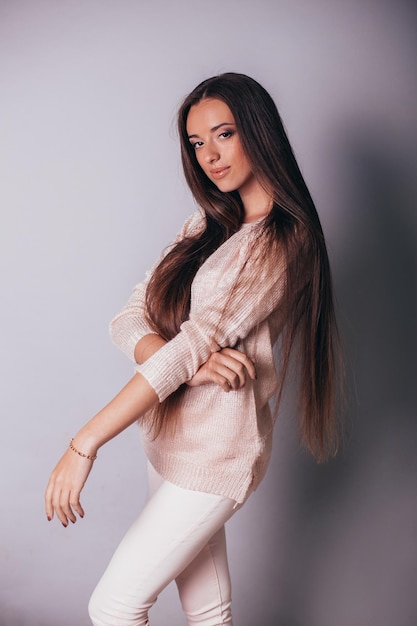 Young woman with long brunette hair in stylish clothes