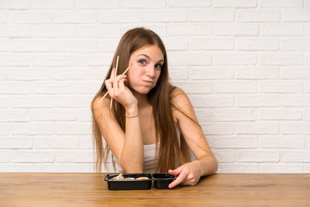 Young woman with long hair eating sushi