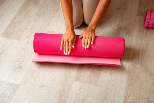 Young woman with long hair fitness instructor in beige sportswear preparing for stretching and