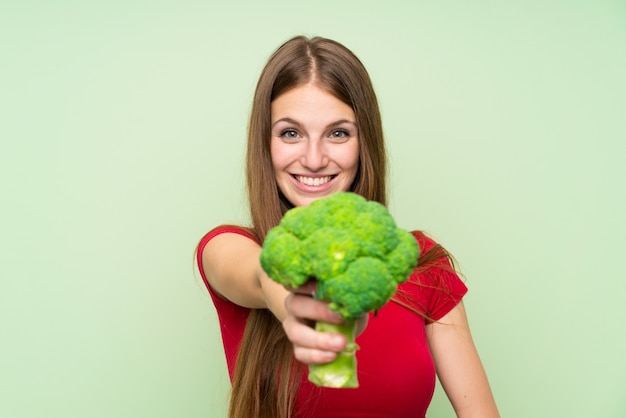 Young woman with long hair holding a broccoli