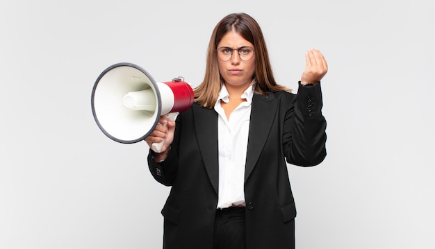 Young woman with a megaphone making capice or money gesture, telling you to pay your debts!