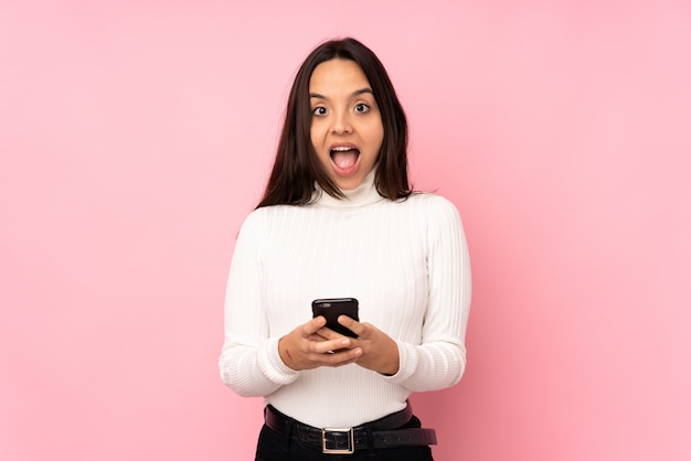 Young woman with a mobile over isolated wall