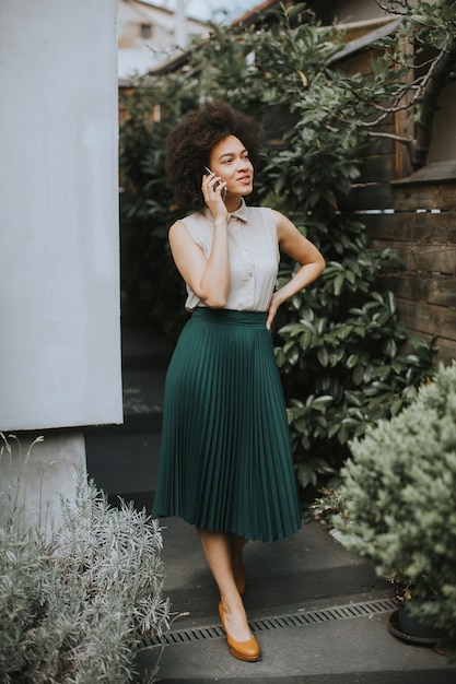 Young woman with a mobile phone in his hand standing in the backyard