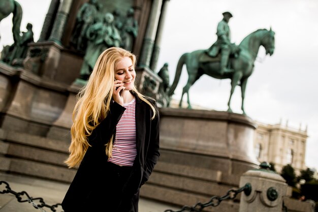 Young woman with mobile phone on the street of Vienna, Austria