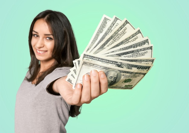 Young woman with money smiling at camera