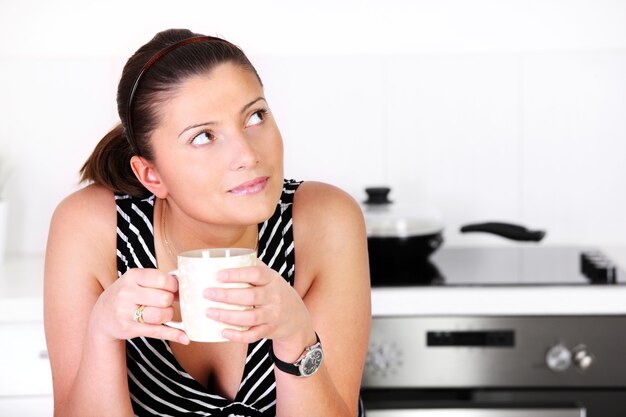 a young woman with morning coffee in the kitchen