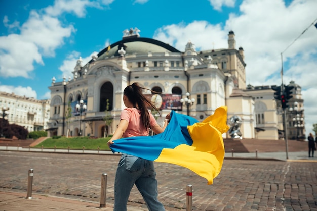 Young woman with national flag of Ukraine on the street