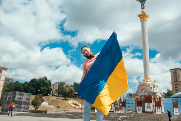 Young woman with national flag of Ukraine on the street