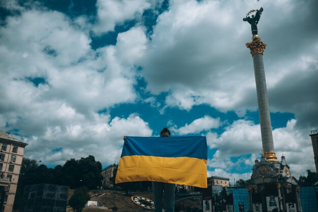 通りにウクライナの国旗を持つ若い女性