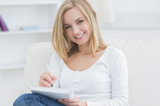 Young woman with notepad and pen at home