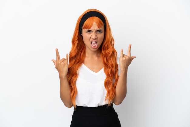 Фото Молодая женщина с оранжевыми волосами, изолированные на белом фоне, делая жест рога