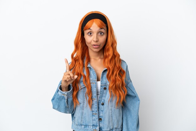 Young woman with orange hair isolated on white background intending to realizes the solution while lifting a finger up