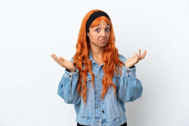 Photo young woman with orange hair isolated on white background making doubts gesture