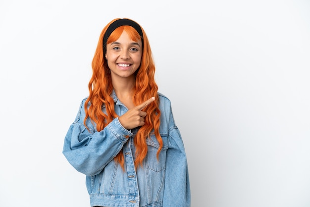製品を提示する側を指している白い背景で隔離のオレンジ色の髪を持つ若い女性