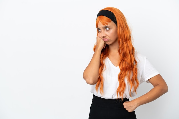 Giovane donna con i capelli arancioni isolata su sfondo bianco con espressione stanca e annoiata