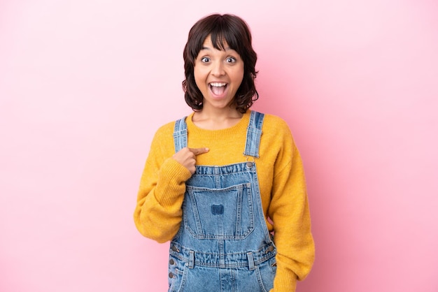 Young woman with overalls isolated background with surprise facial expression