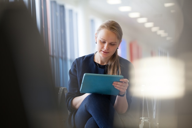 Young woman with pad in the waiting room