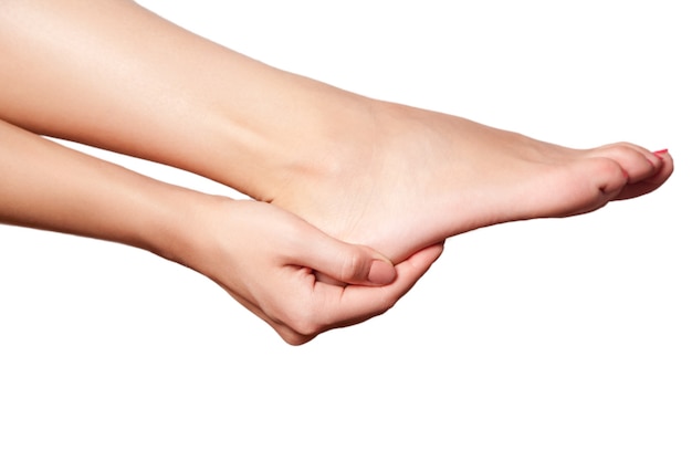 Young woman with pain on leg on white background