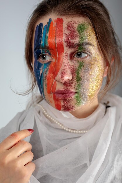 Photo young woman with painted face against gray background