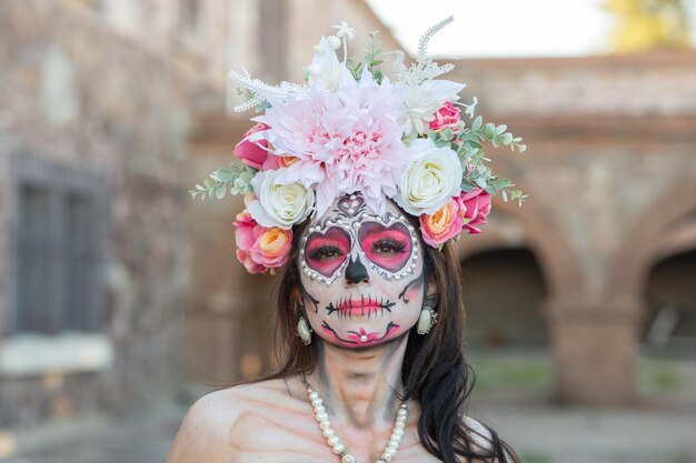 メキシコの死者の日に描かれた顔と砂糖の頭蓋骨の若い女性 El Dia de Muertos in fo