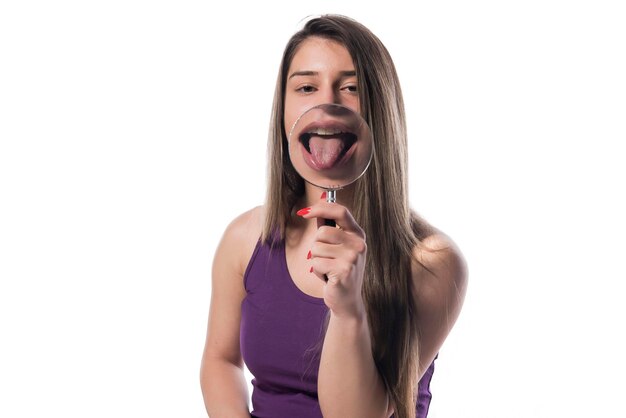 young woman with perfect smile and healthy teeth behind magnifying glass