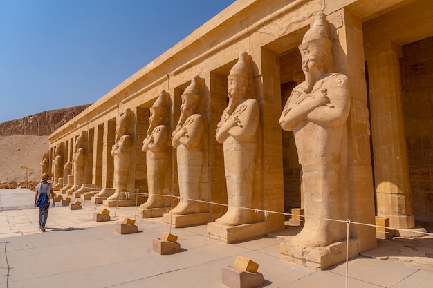 A young woman with pharaoh sculptures entering Hatshepsut's Funerary Temple in Luxor. Egypt