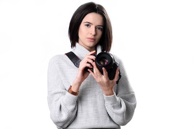 Молодая женщина с фотоаппаратом на белом фоне