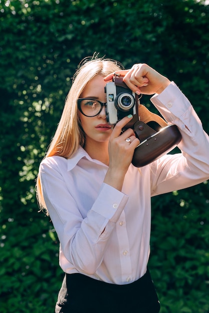 写真のカメラを持つ若い女性