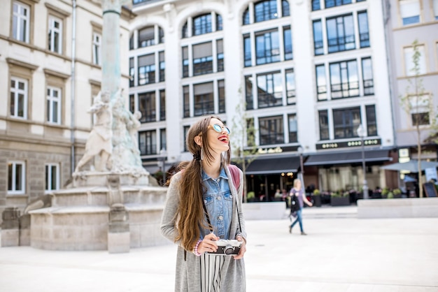 Молодая женщина с фотоаппаратом, путешествующая по Старому городу Люксембурга